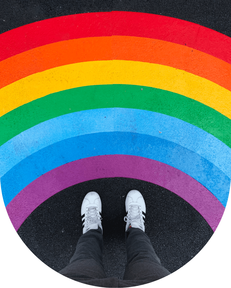 Vista de unos pies debajo de un arcoiris pintado en el suelo
